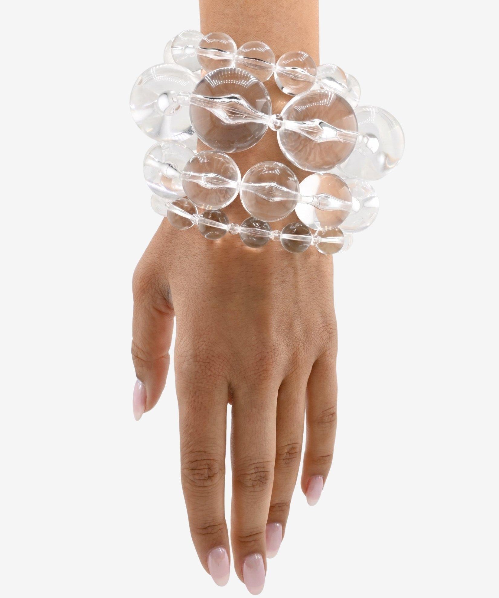 Clear, glass-like lucite bracelet stack on a wrist