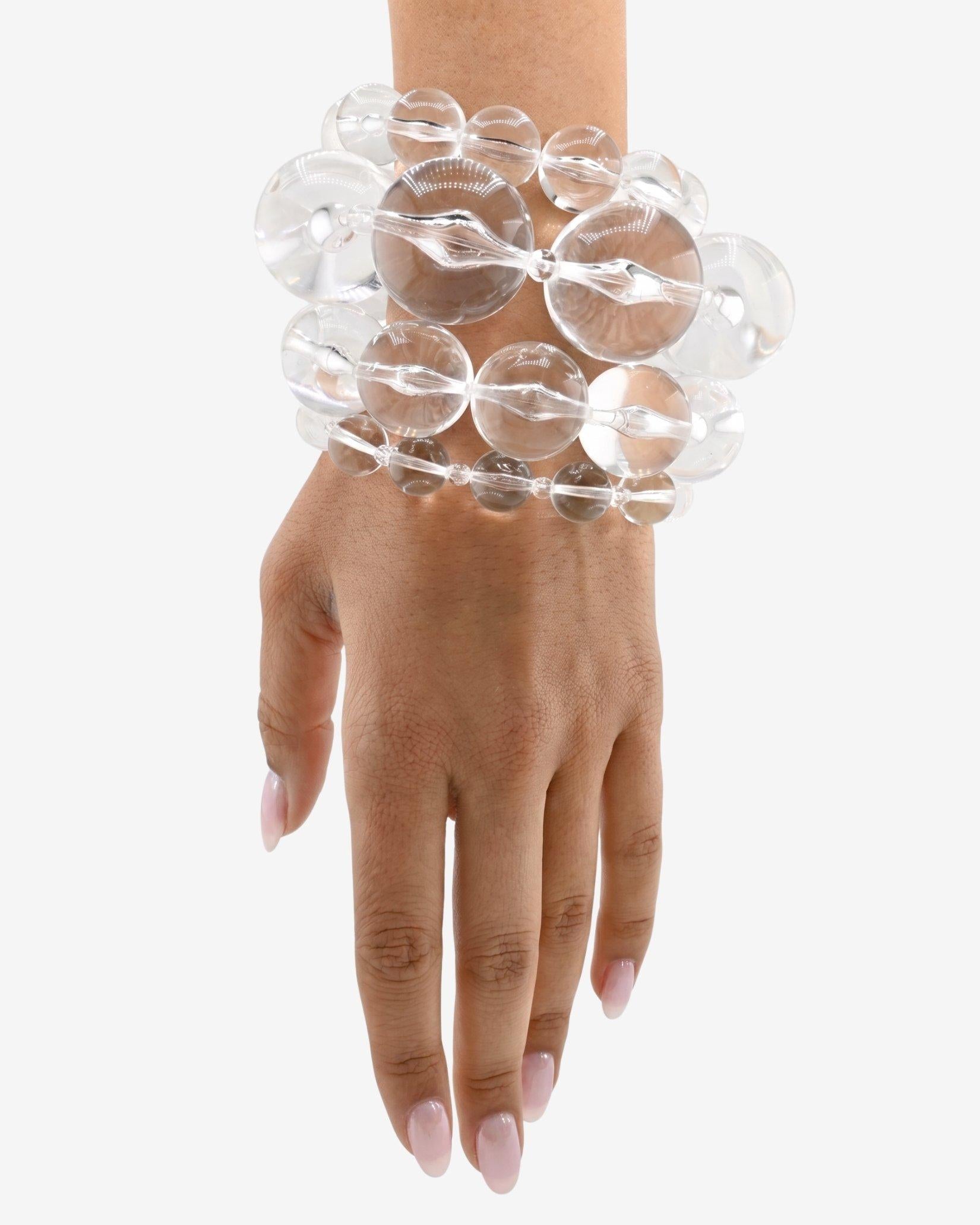 Clear, glass-like lucite bracelet stack on a wrist