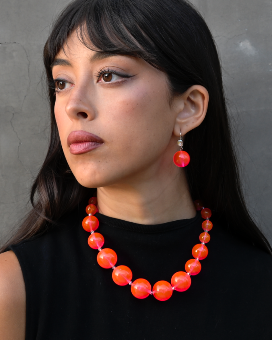 model wearing neon bubble earrings in pink color